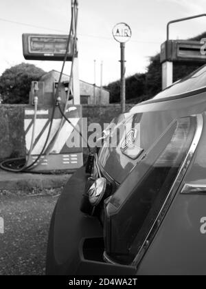 Ein klassischer MGB GT ruht vor einer verlassenen Tankstelle Stockfoto