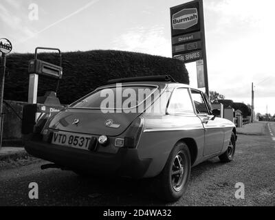 Ein klassischer MGB GT ruht vor einer verlassenen Tankstelle Stockfoto