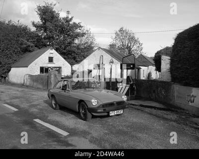 Ein klassischer MGB GT ruht vor einer verlassenen Tankstelle Stockfoto