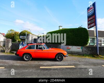 Ein klassischer MGB GT ruht vor einer verlassenen Tankstelle Stockfoto