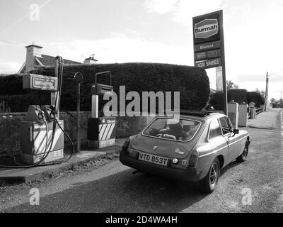 Ein klassischer MGB GT ruht vor einer verlassenen Tankstelle Stockfoto