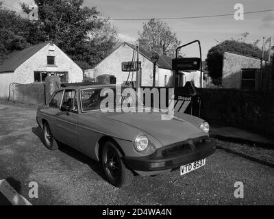 Ein klassischer MGB GT ruht vor einer verlassenen Tankstelle Stockfoto