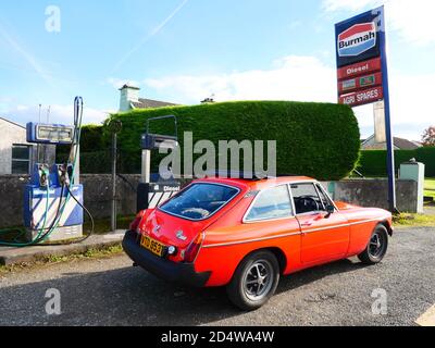 Ein klassischer MGB GT ruht vor einer verlassenen Tankstelle Stockfoto