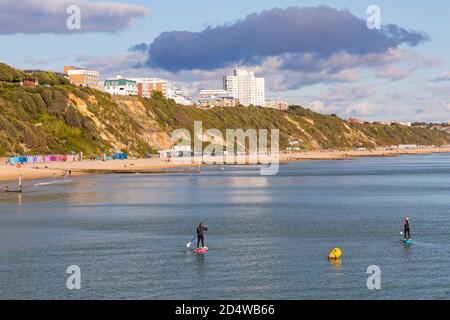 Bournemouth, Dorset, Großbritannien. Oktober 2020. Wetter in Großbritannien: Paddelboarder genießen die herrliche Abendsonne an den Stränden von Bournemouth, während die Sonne die Klippen und den Strand umspült. Quelle: Carolyn Jenkins/Alamy Live News Stockfoto