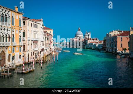 Blick über den Canale Grande mit der Basilika Santa Maria della Salute von der Brücke Ponte dell' Academia in Venedig, Italien. Stockfoto