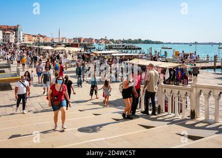 Touristen auf Ponte della Paglia, San Marco mit chirurgischen Masken und Souvenirständen an der venezianischen Lagune während der Coronavirus-Krise. Stockfoto