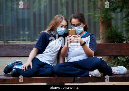 Zwei 11-jährige Mädchen, die ein Smartphone betrachten, Barcelona. Stockfoto