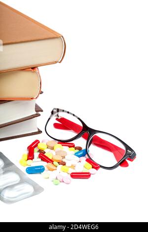 Stapel von Büchern und Pillen, Kapseln isoliert auf weißem Hintergrund. Arzneimittel. Medikamente und Medikamente. Stockfoto