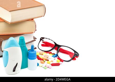 Stapel von Büchern und Pillen, Kapseln isoliert auf weißem Hintergrund. Arzneimittel. Medikamente und Medikamente. Stockfoto