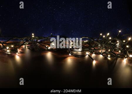 led weihnachtsbeleuchtung auf Holz und hellblauen Hintergrund. weihnachtsdekoration. weihnachtskarte Bild Stockfoto
