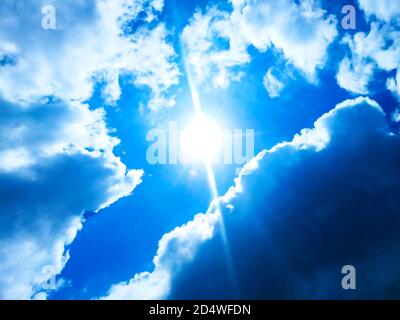 Sonnig, blauer Himmel mit weißen Wolken und Sonne Stockfoto