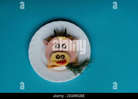 Lustige Sandwich mit essbaren Symbol von 2021 Stier Kuh aus Toast Brot, Wurst und Käse, Frühstück Idee für Kinder. Urlaub, Feier, Essen Kunst. Stockfoto