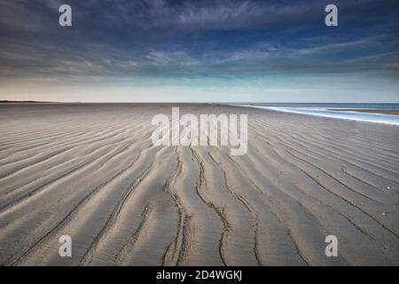 Wellen Sie Sand Texturen am Strand bei Ebbe Stockfoto