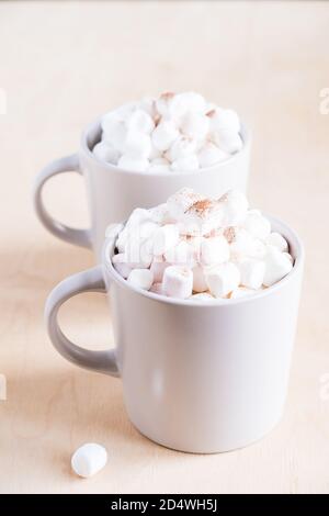Zwei Tassen heißer Kakao mit Marshmallows auf Holzhintergrund. Stockfoto