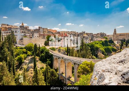 Gravina in Apulien, Italien. Die Steinbrücke, das antike Aquädukt und das Viadukt. Über das Tal die Skyline der Stadt mit ihren Häusern und Gebäuden und Stockfoto