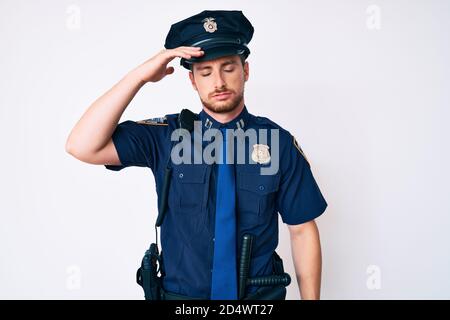 Junger kaukasischer Mann in Polizeiuniform besorgt und gestresst über ein Problem mit der Hand auf der Stirn, nervös und besorgt für Krise Stockfoto