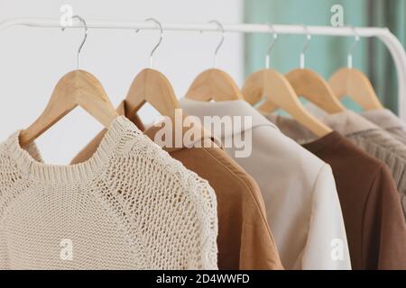 Kleidung hängt an hölzernen Kleiderbügeln im Modegeschäft in der Nähe. Stockfoto