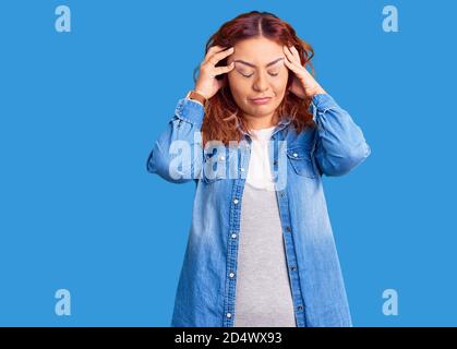 Junge lateinische Frau trägt Casual Kleidung leiden unter Kopfschmerzen verzweifelt und gestresst, weil Schmerzen und Migräne. Hände auf dem Kopf. Stockfoto