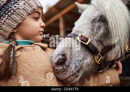 Pony Kuscheln Bis Zu Kleinen Mädchen Stockfoto