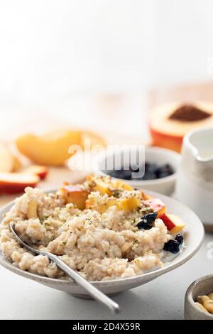 Gesunde Haferflocken Haferbrei mit Früchten und Hanfsamen zum Frühstück. Vegan, vegetarisches Frühstückskost Konzept Stockfoto