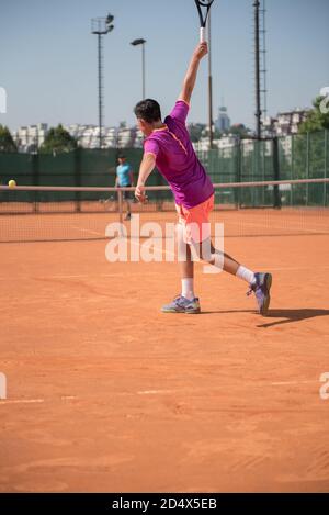 Junger Tennisspieler spielt Backhand Stockfoto