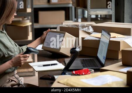 Verkäuferin Scannen E-Commerce-Versandkarton in Dropshipping Lager. Stockfoto