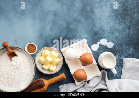 Zutaten zum Backen auf blauem Hintergrund. Mehl Eier Butter Gewürze und Milch Stockfoto