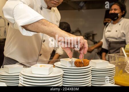 Mexiko-Stadt, Mexiko. Oktober 2020. CANCUN, MEXIKO - OKTOBER 10: Küchenchef David Nunez bereitet ein Gericht vor Essen ergreift Sicherheitsmaßnahmen während der Einweihung des brasilianischen Restaurants 'Divina Carne' inmitten der Coronavirus-Pandemie am 10. Oktober 2020 in Cancun, Mexiko. Kredit: Ismael Rosas/Eyepix Gruppe/Der Fotozugang Gutschrift: Der Fotozugang/Alamy Live Nachrichten Stockfoto