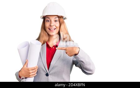 Schöne junge Frau trägt Architekt Hardhat halten bauen Projekt lächelnd Glücklich zeigen mit Hand und Finger Stockfoto