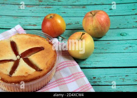 Quark Apfelpudding und Äpfel auf Serviette auf blauem Holzhintergrund flach legen. Das Bild enthält den Kopierbereich Stockfoto