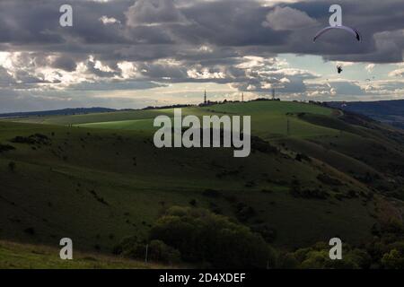 Devils Dyke, East Sussex, Großbritannien, 11. Oktober 2020. An einem windigen Nachmittag im Herbst schweben Paragleiter über die South Downs. Wolkiger Himmel und Schatten über den Wellen der Tiefen. ©Sarah Mott / Alamy Live Nachrichtenquelle: Sarah Mott/Alamy Live Nachrichten Stockfoto