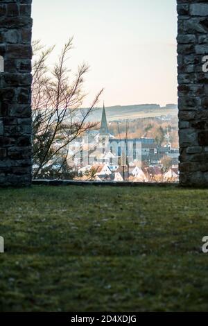 Blick auf eine Stadt und eine Kirche unten durch eine Portal in den Ruinen Stockfoto