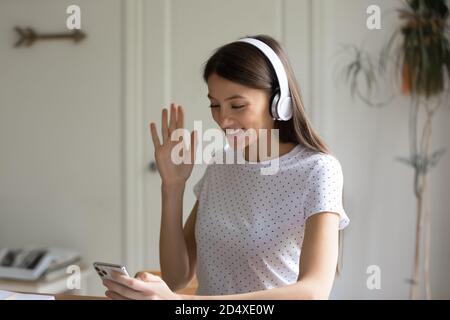 Lächelnde junge Frau hält Videoanruf per Smartphone. Stockfoto
