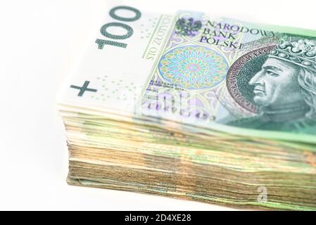 Ein Stapel gestapelter 100 polnischer Zloty-Papierbanknoten, isoliert auf weißem Hintergrund. Stockfoto