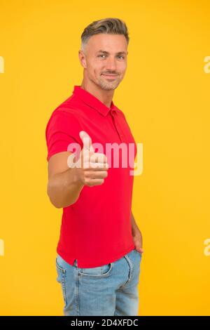Sei dein Bestes. Glücklicher Kerl geben Daumen nach oben gelben Hintergrund. Geste zur Genehmigung. Handzeichen. Lässige Mode. Modischer Style. Modische Herrenmode. Herrenbekleidung. Es verdient Daumen nach oben. Stockfoto