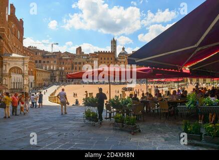 Outdoor-Café überfüllt mit Touristen auf der Piazza del Campo, Hauptplatz der Altstadt von Siena, UNESCO W. Heritage Site, im Sommer Tag, Toskana, Italien Stockfoto