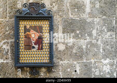 Metallrahmen mit den Symbolen der Contrada del Leocorno, einer der 17 historischen Unterteilungen von Siena, auf einer alten Backsteinmauer, Toskana, Italien Stockfoto