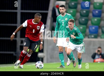 Der Österreicher David Alaba (links) kämpft mit Conor McLaughlin (Mitte) und Gavin Whyte während des UEFA Nations League Group 1, League B-Spiels im Windsor Park, Belfast, um den Ball. Stockfoto