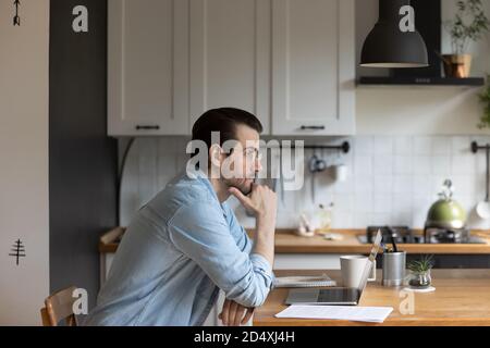 Abgelenkt von Computerarbeit junger Mann wegschauen. Stockfoto