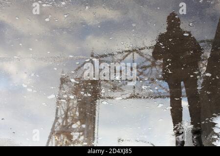 Reflexion in einer Pfütze einer Person, die neben der Lift Bridge in Duluth, Minnesota, steht. Stockfoto
