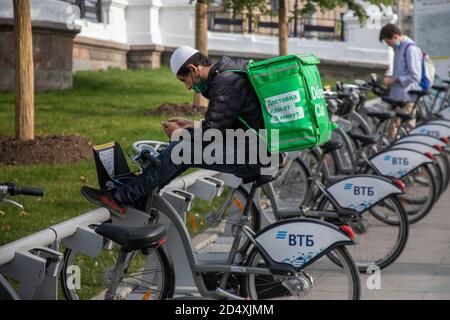 Moskau, Russland. 3. Oktober 2020 EIN Kurier des beliebten Food Delivery Service 'Delivery Club' mietet ein Fahrrad auf der Verleihstation im Zentrum von Moskau Stockfoto