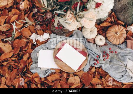 Herbsthochzeit, Geburtstag Mockup Szene. Blumenstrauß mit Olivenzweigen, Mütter, Hortensien und rosa Rosenblüten. Leere Papierkarten auf Holzplatte Stockfoto