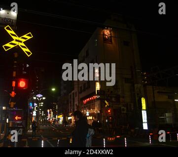 Itabashi-Tokyo, Japan-2/22-16: Nachtaufnahme des Itabashi-Zuges, als die Bürger auf den Zug warten, um ihn zu überqueren. Stockfoto