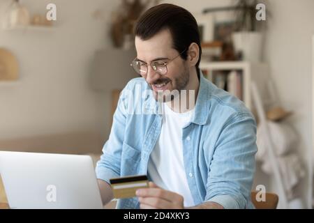 Glücklicher junger Mann in der Brille beim Einkaufen. Stockfoto