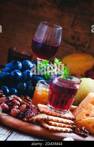 Rosenwein und Holzgericht mit verschiedenen Snacks, Vintage-Hintergrund, selektiver Fokus Stockfoto