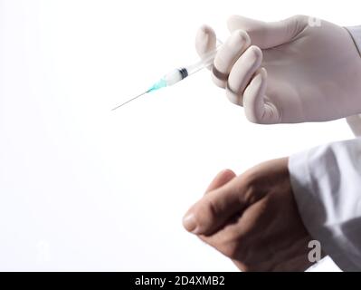 Ärzte bieten Impfstoff mit freundlicher Geste, Spritze und Handschuh, weißer Hintergrund Stockfoto