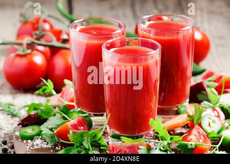 Frischer Saft aus der Mischung aus Gemüse mit Gemüse und Kräutern auf einem Holztisch, selektiver Fokus Stockfoto
