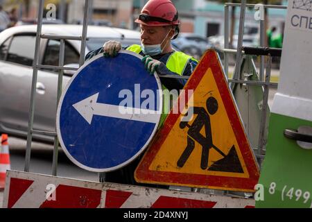 Moskau, Russland. 3. Oktober 2020 EIN Arbeiter des Moskauer Verkehrsmanagementzentrums richtet Straßenschilder ein, um den Fahrzeugverkehr während der Reparaturarbeiten auf der Straße im Stadtzentrum von Moskau, Russland, zu begrenzen Stockfoto