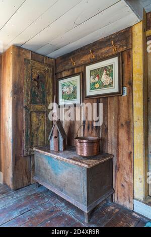 Vogelhaus aus Holz und Kupfertopf auf einem antiken Holzschrank in der Erweiterung mit Scheunenholzwänden in einem alten Haus im Landhausstil von 1841. Stockfoto