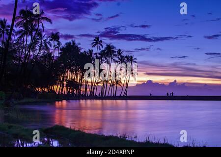 Sonnenuntergang mit Palmen am Waikoloa Strand (Anaehoomalu Bucht) mit buntem Himmel, Big Island, Hawaii Stockfoto